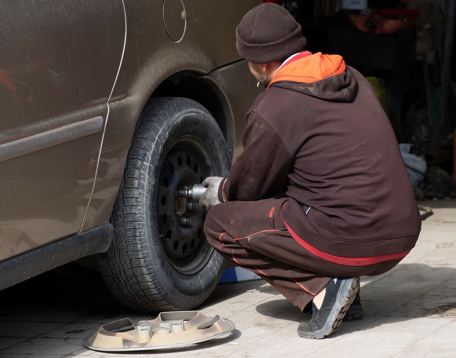 فني يبدل إطار سيارة